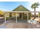 Green house with a covered patio and stone pathway, offering a welcoming entrance at 59 N Adams St, Wickenburg, AZ 85390