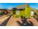 Green bungalow with a covered patio and walkway, showcasing a charming curb appeal at 59 N Adams St, Wickenburg, AZ 85390