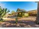 Green house with a covered patio and desert landscaping at 59 N Adams St, Wickenburg, AZ 85390