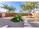 Landscaped backyard with gravel, stone path, and mature trees at 5902 W Gambit Trl, Phoenix, AZ 85083