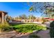 Landscaped backyard with curved lawn, pool, and patio area at 5902 W Gambit Trl, Phoenix, AZ 85083