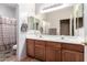 Bathroom with double sinks and wood cabinets at 5902 W Gambit Trl, Phoenix, AZ 85083