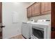 Laundry room with washer, dryer, and wooden cabinets at 5902 W Gambit Trl, Phoenix, AZ 85083