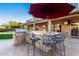 Elegant outdoor kitchen with granite counter, built-in appliances, and seating at 5902 W Gambit Trl, Phoenix, AZ 85083