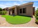 Exterior view of the covered patio and the turf backyard, with a rock border and easy access to the building at 6202 E Mckellips Rd # 83, Mesa, AZ 85215