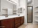 Bathroom with double sink vanity, tiled floors, a glass-enclosed shower, and linen storage at 6202 E Mckellips Rd # 83, Mesa, AZ 85215