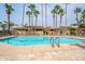 Inviting community swimming pool surrounded by palm trees at 6202 E Mckellips Rd # 83, Mesa, AZ 85215