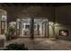 View of the backyard through open French doors, showing a dining area and fireplace at 8408 E La Senda Dr, Scottsdale, AZ 85255