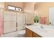 Bathroom with single vanity, tub, and sliding glass shower door at 9345 E Hobart St, Mesa, AZ 85207