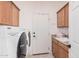 Laundry room with washer, dryer, utility sink, and ample cabinetry at 9345 E Hobart St, Mesa, AZ 85207