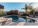 Freeform swimming pool with a waterfall feature, surrounded by lush landscaping at 9345 E Hobart St, Mesa, AZ 85207