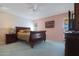 Bedroom with a wooden sleigh bed and light blue carpet at 9719 W Pineridge Dr, Sun City, AZ 85351