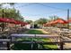 Outdoor community patio with picnic tables and red umbrellas at 10315 E Palladium Dr, Mesa, AZ 85212