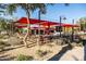 Outdoor seating area with red shade umbrellas and a concession stand at 10315 E Palladium Dr, Mesa, AZ 85212