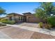 One-story home with a brick facade, attached garage, and landscaped front yard at 10315 E Palladium Dr, Mesa, AZ 85212