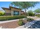 Tan colored home with a brick base and lush landscaping at 10315 E Palladium Dr, Mesa, AZ 85212