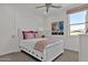 Bright bedroom with a white bed, patterned bedding, and ceiling fan at 1115 E Gleneagle St, Chandler, AZ 85249