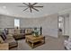 Open loft area featuring a sectional sofa, coffee table, and brick accent wall at 1115 E Gleneagle St, Chandler, AZ 85249