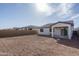 View of the home's backyard with dirt, patio, and privacy wall at 12766 W Parkway Ln, Avondale, AZ 85323