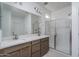 Modern bathroom featuring a double vanity, quartz countertops, and a glass-enclosed shower for a spa-like feel at 12766 W Parkway Ln, Avondale, AZ 85323