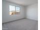 Bright bedroom featuring neutral carpet and a large window offering natural light and neighborhood views at 12766 W Parkway Ln, Avondale, AZ 85323