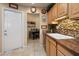 Kitchen features light wood cabinets, granite counters and a double sink at 13606 N 108Th Dr, Sun City, AZ 85351