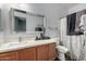 Bathroom with a vanity, shower/tub, and gray-patterned shower curtain at 16173 W Monroe St, Goodyear, AZ 85338