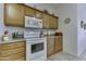 Kitchen with white appliances and light wood cabinets at 17200 W Bell Rd # 2255, Surprise, AZ 85374