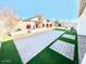 Landscaped backyard with paved patio and artificial grass at 18352 W Chama Dr, Wittmann, AZ 85361