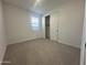 Bedroom with neutral colored carpet, closet, neutral paint, and a window at 22852 E Lords Way, Queen Creek, AZ 85142