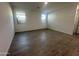 Bedroom featuring wood-look tile floors, two windows, and closet access at 22852 E Lords Way, Queen Creek, AZ 85142