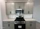 Close-up of a kitchen featuring stainless steel appliances and gray cabinets at 22852 E Lords Way, Queen Creek, AZ 85142