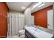 Bathroom with rust colored walls, white vanity, and shower at 25417 S Kansas Ave, Sun Lakes, AZ 85248