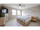 Bedroom with light wood platform bed, dresser, and large TV at 25417 S Kansas Ave, Sun Lakes, AZ 85248