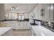 Modern white kitchen with glass-front cabinets and tile backsplash at 25417 S Kansas Ave, Sun Lakes, AZ 85248