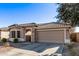 One-story house with tan exterior, tile roof, and two-car garage at 25583 W Beth Dr, Buckeye, AZ 85326