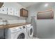 Convenient laundry room with washer, dryer, and overhead storage at 25583 W Beth Dr, Buckeye, AZ 85326