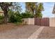 Landscaped backyard with a wooden gate and a stone pathway at 3034 N Ricardo --, Mesa, AZ 85215