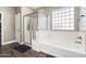 Bathroom with soaking tub, shower, and dark-colored tile flooring at 4058 E Mesquite St, Gilbert, AZ 85296