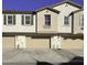 Tan, two-story townhome with three-car garage and desert landscaping at 4130 E Pinto Dr, Gilbert, AZ 85296