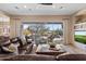 Spacious living room with leather sofas, a stone fireplace, and sliding glass doors leading to the pool at 41711 N Maidstone Ct, Anthem, AZ 85086