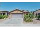 House exterior showcasing a two-car garage and desert landscaping at 46166 W Sheridan Rd, Maricopa, AZ 85139