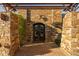 Elegant entry with stone pillars, arched double doors, and pergola at 4836 E Moonlight Way, Paradise Valley, AZ 85253