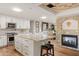 Island kitchen features granite counters, white cabinets, and a cozy fireplace at 4836 E Moonlight Way, Paradise Valley, AZ 85253