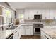 Bright kitchen with granite counters, white cabinets, and patterned tile backsplash at 4836 E Moonlight Way, Paradise Valley, AZ 85253