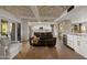 Open living area features hardwood floors, a stone fireplace, and views into the kitchen at 4836 E Moonlight Way, Paradise Valley, AZ 85253