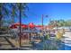 Community patio dining area with red umbrellas and string lights at 5015 S Quantum Way, Mesa, AZ 85212