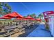 Community patio dining area with red umbrellas and string lights at 5015 S Quantum Way, Mesa, AZ 85212