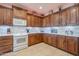 Bright kitchen boasts white appliances and rich wood cabinets at 5500 N Globe Dr, Eloy, AZ 85131