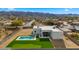 Aerial view showcasing a modern home with pool and putting green, mountain backdrop at 744 E Desert Ln, Phoenix, AZ 85042